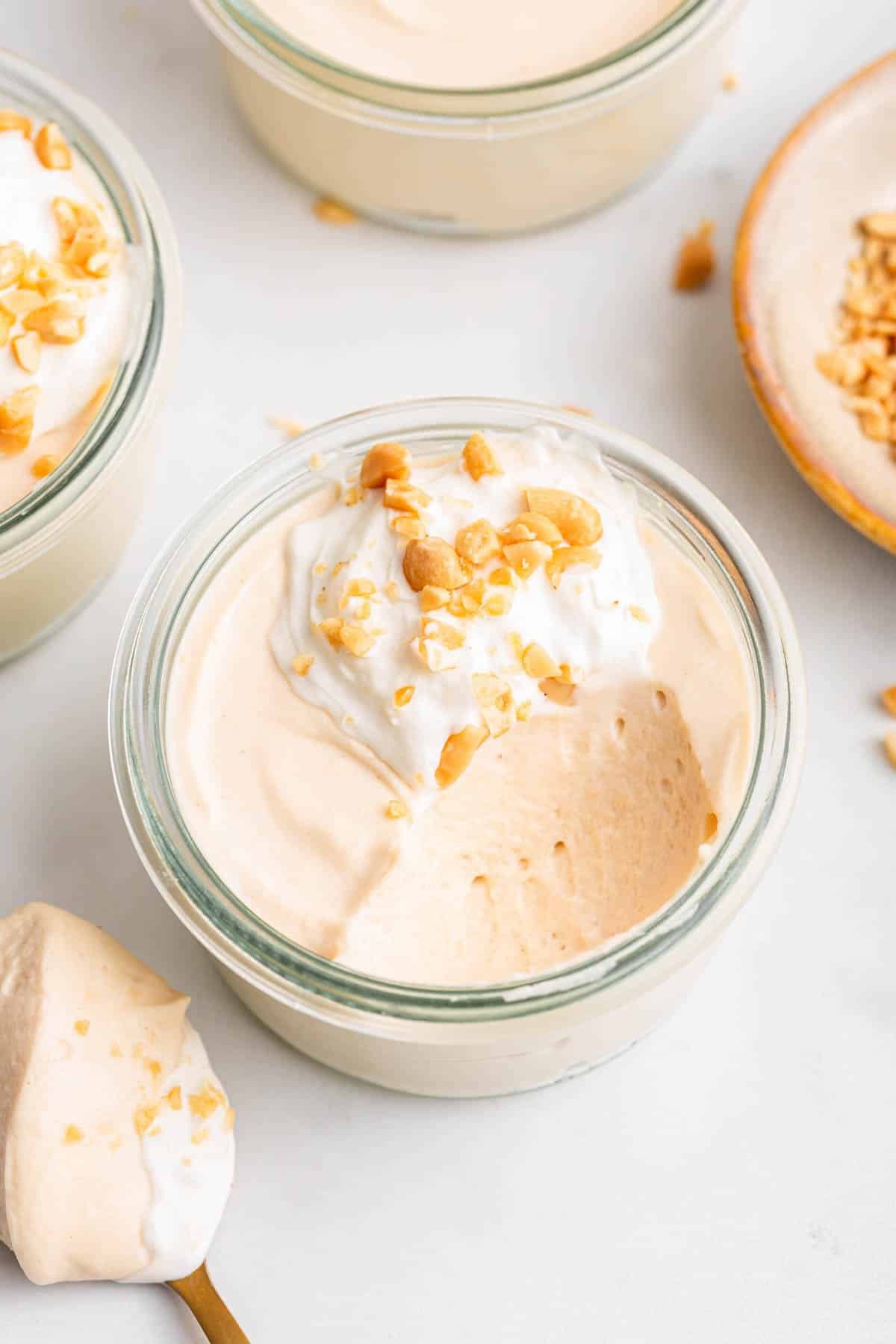 Small bowl of peanut butter mousse with one bite missing to show interior texture.