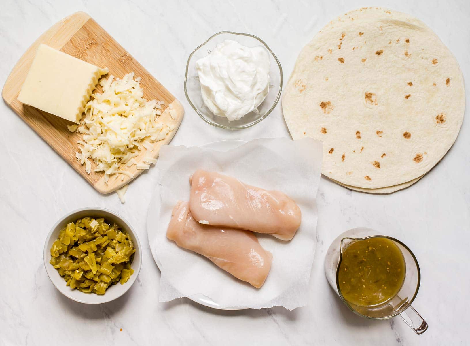 Ingredients for white chicken enchiladas on white table.