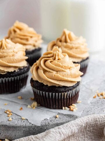 Four chocolate peanut butter cupcakes on grey tray.