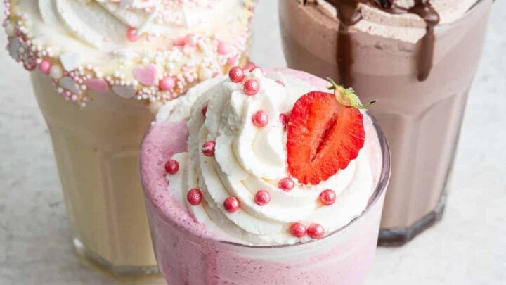 Bild von 3 Gläsern Milchshakes: Erdbeere vorne, Schokolade und Vanille hinten.