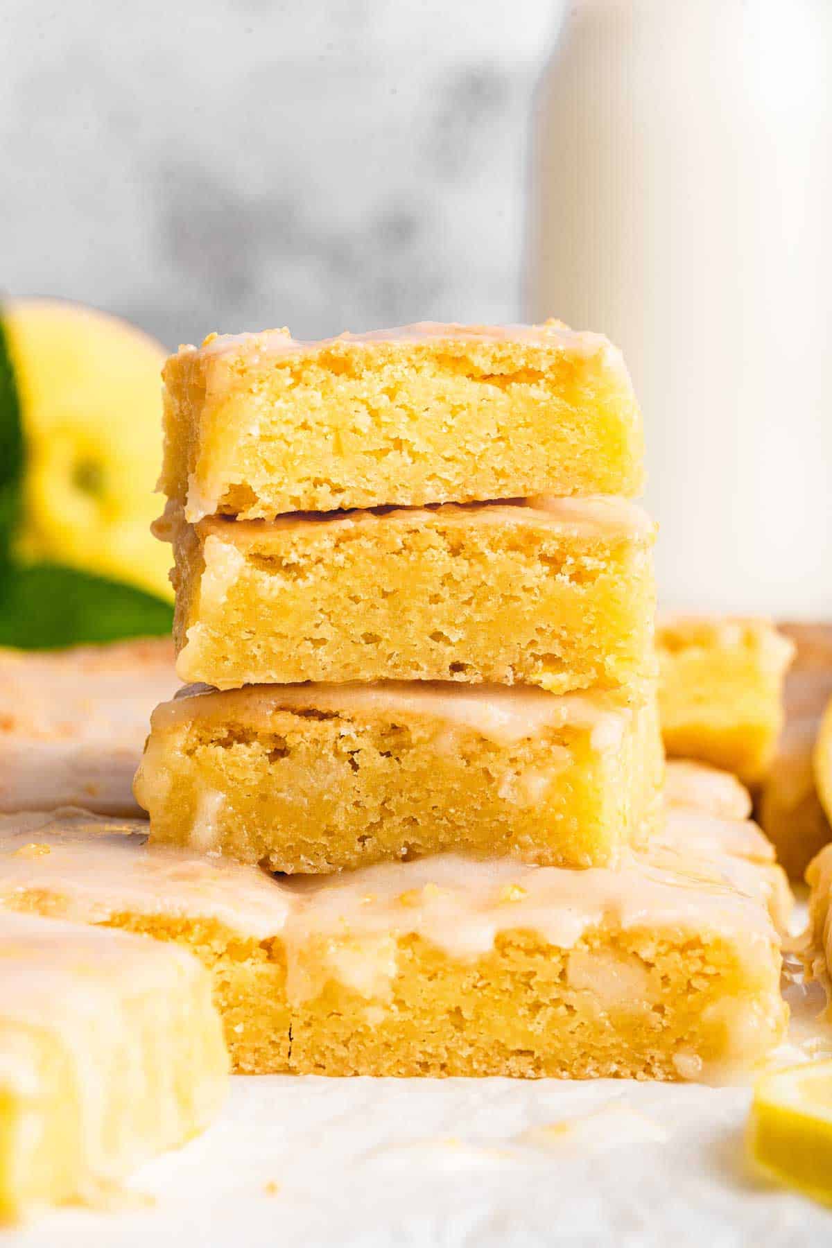 Three stacked lemon brownies on a grey surface.